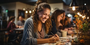 a person smiling while writing on a paper