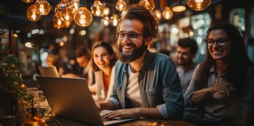 a person sitting at a table with a laptop