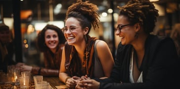 a group of women sitting at a table laughing