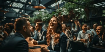 a group of people sitting at a table laughing