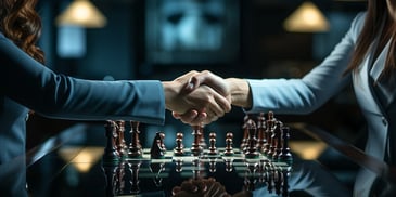 hands shaking hands over a chess board