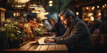 a person sitting at a table with a laptop