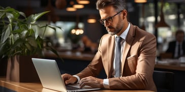 a person in a suit and tie working on a laptop