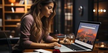 a person sitting at a desk using a laptop