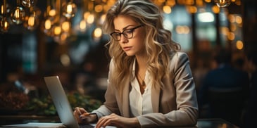 a person in glasses working on a laptop