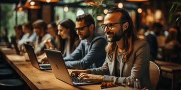 a group of people sitting at a table with a laptop